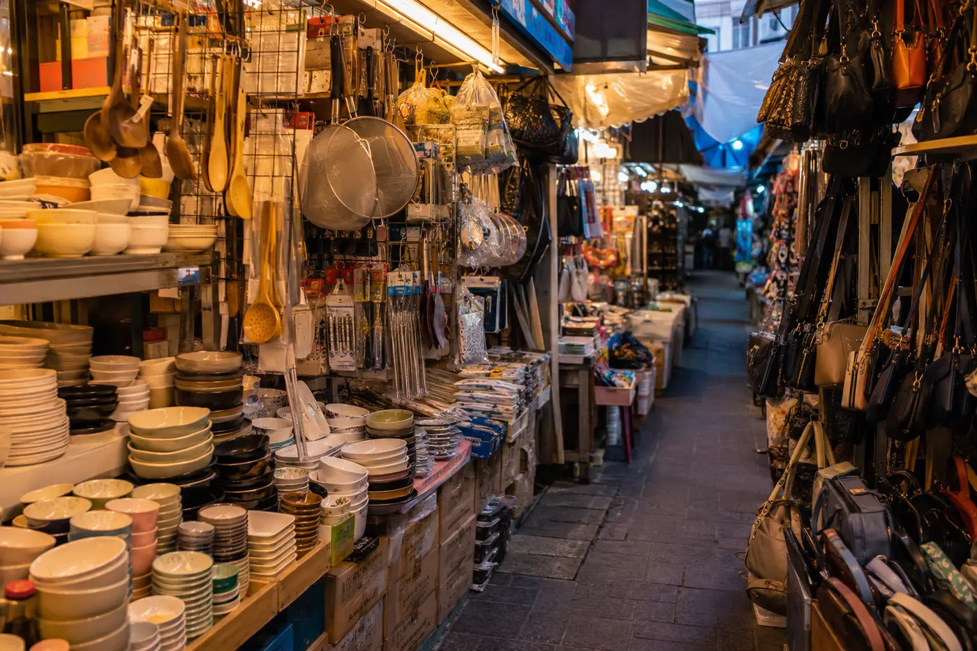 A dense but readable Namdaemun market lane with household and accessory stalls