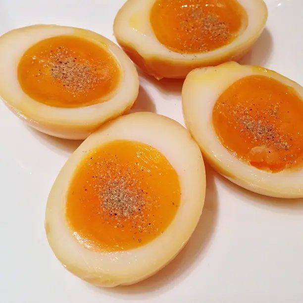 Telur asap yang dibelah dengan putih telur berwarna coklat