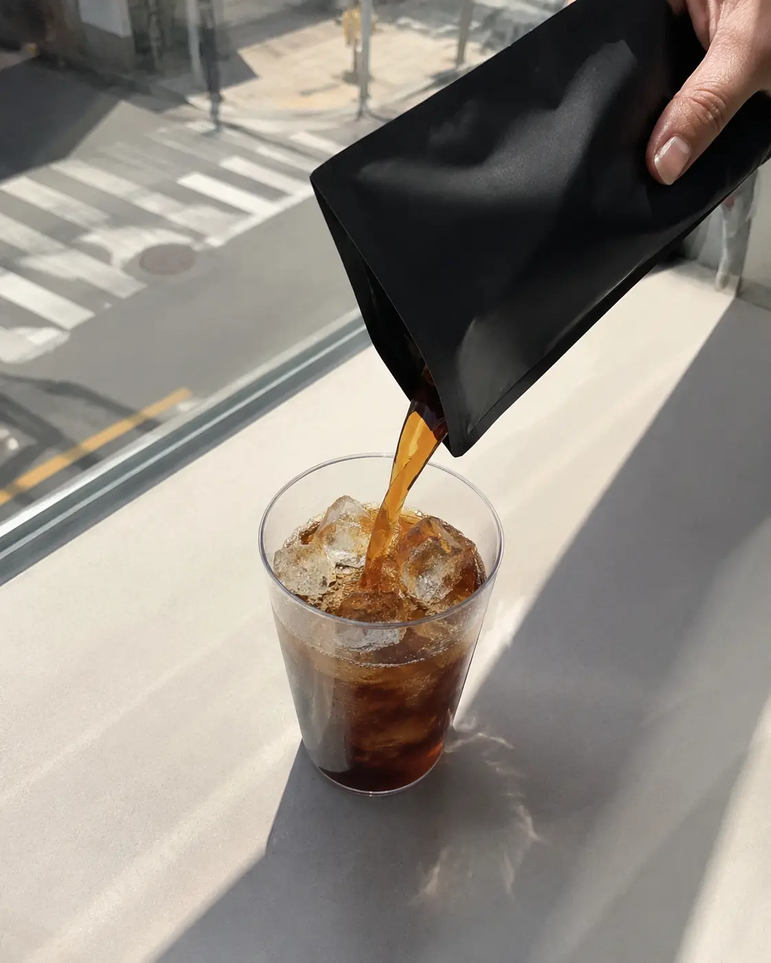 Kopi pouch dituangkan ke dalam cup es di konter toko serba ada