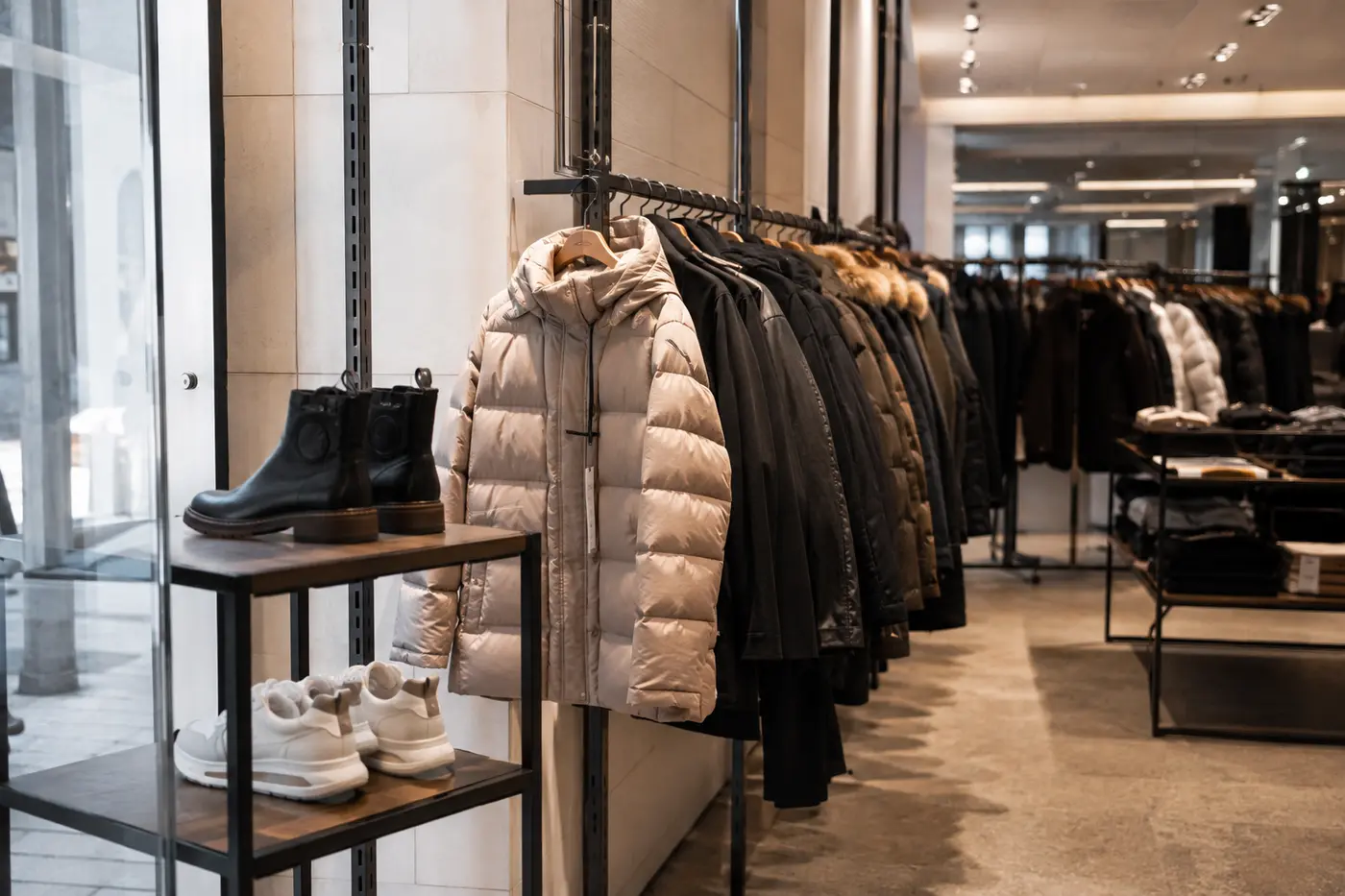 Past-season luxury outerwear and shoes in an orderly outlet environment