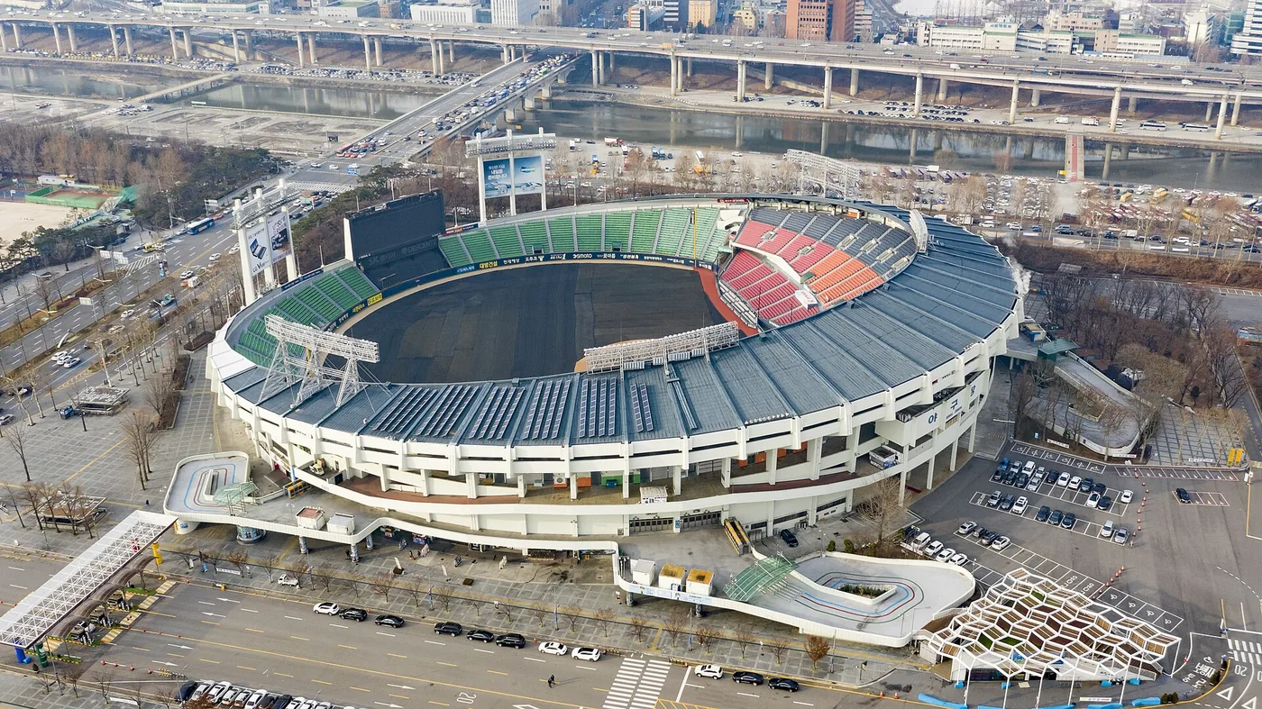 Fans arriving at Jamsil Baseball Stadium beside the Seoul skyline