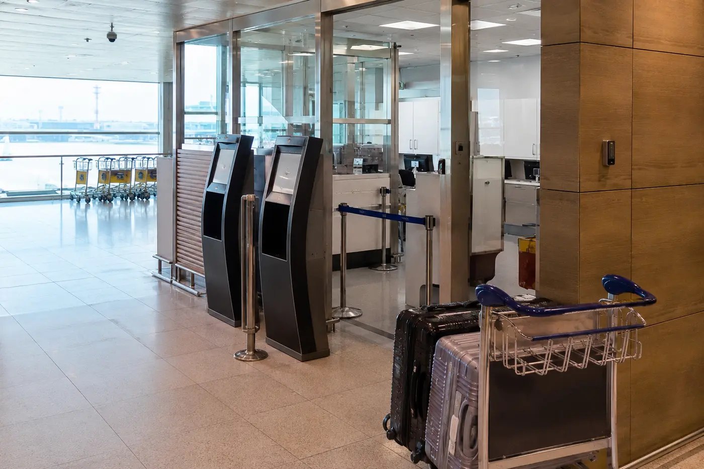 An airport tax-refund area with luggage, customs signage and self-service kiosks
