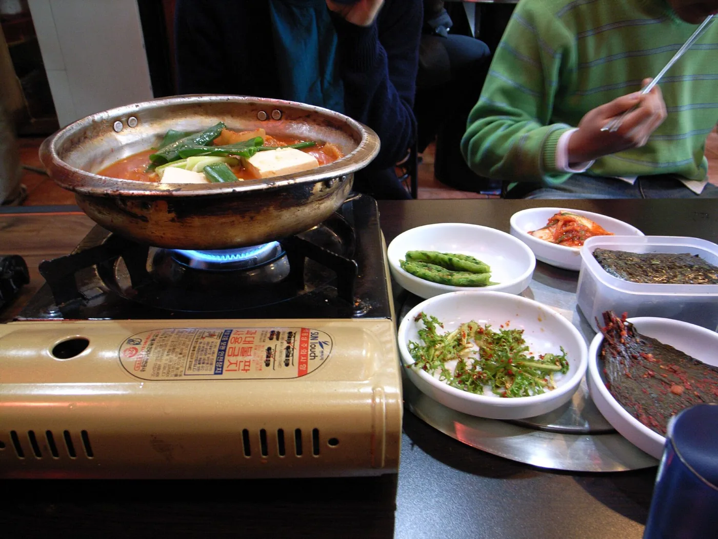 A bubbling bowl of red kimchi jjigae served with rice