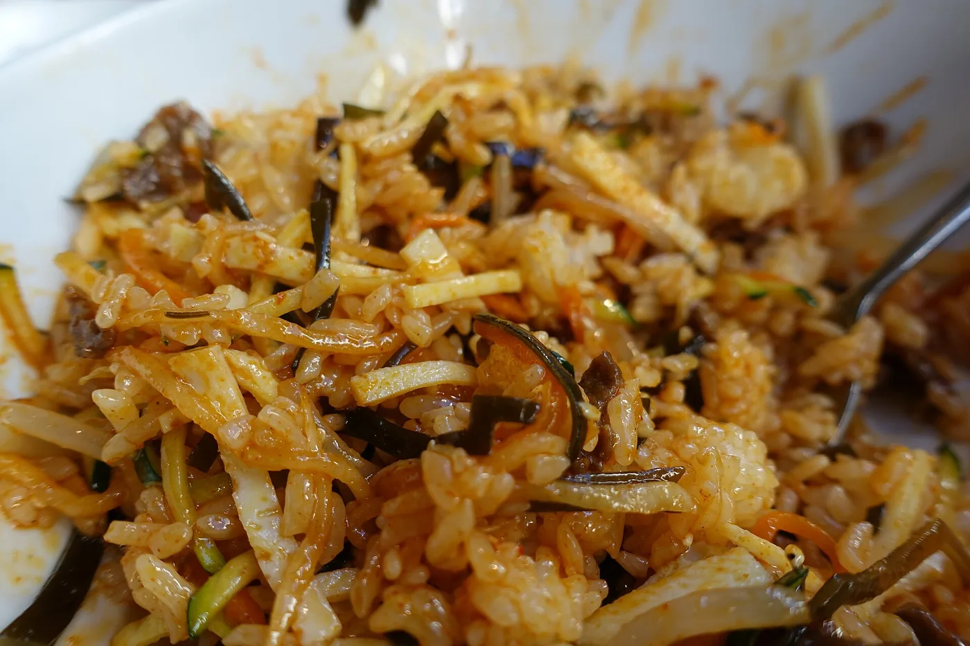 A bowl of bibimbap topped with vegetables, beef and egg