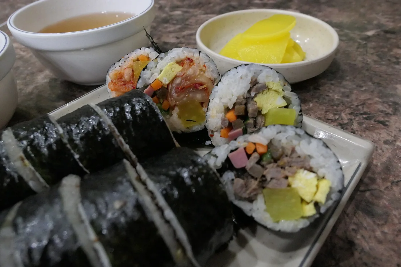 Sliced gimbap showing rice, vegetables and fillings wrapped in seaweed