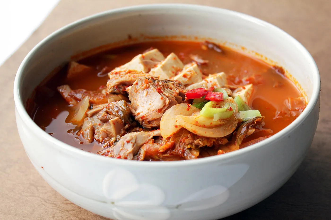 A bubbling bowl of red kimchi jjigae served with rice
