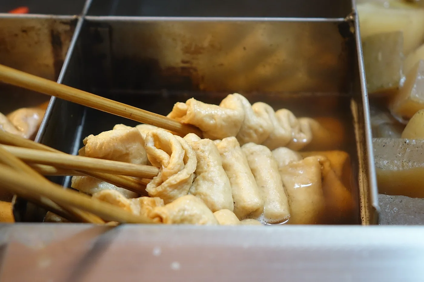 Folded eomuk fish cakes served on skewers at a street stall