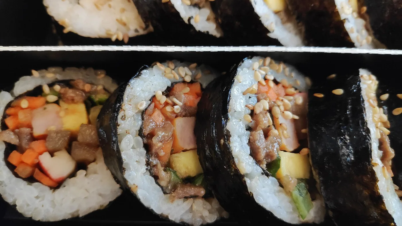 Sliced gimbap showing rice, vegetables and fillings wrapped in seaweed