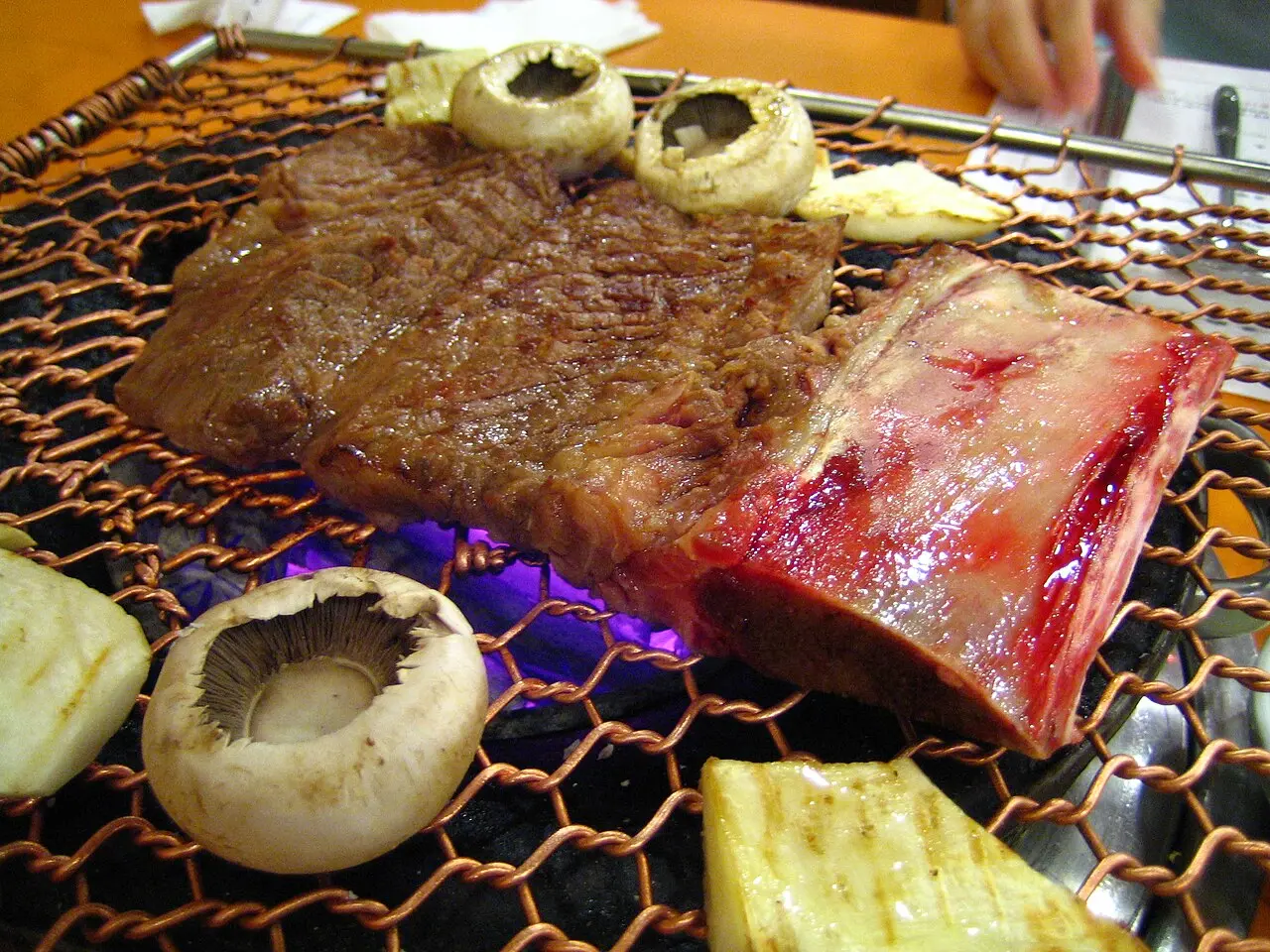Korean galbi ribs grilling over a tabletop flame