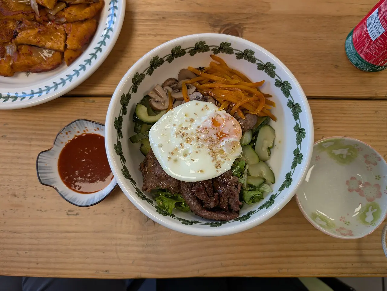 A bowl of bibimbap topped with vegetables, beef and egg
