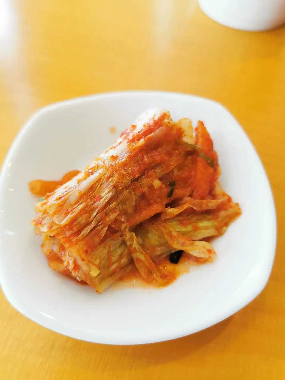 Napa cabbage kimchi on a white plate
