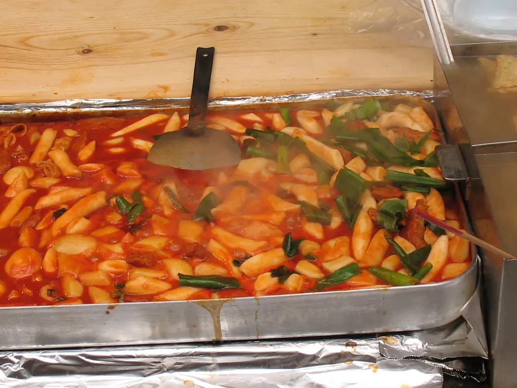 Tteokbokki rice cakes simmering in a red gochujang sauce
