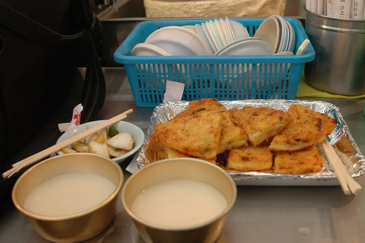 Golden bindaetteok mung-bean pancakes served with makgeolli
