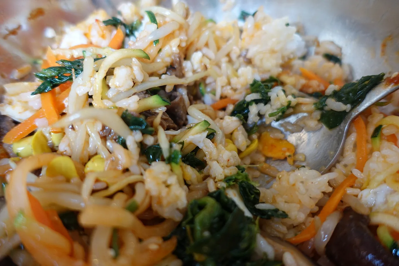A bowl of bibimbap topped with vegetables, beef and egg