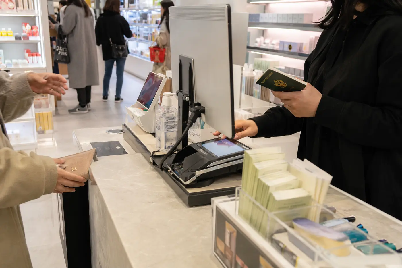 A Korean beauty checkout with passport, card terminal and tax-refund information