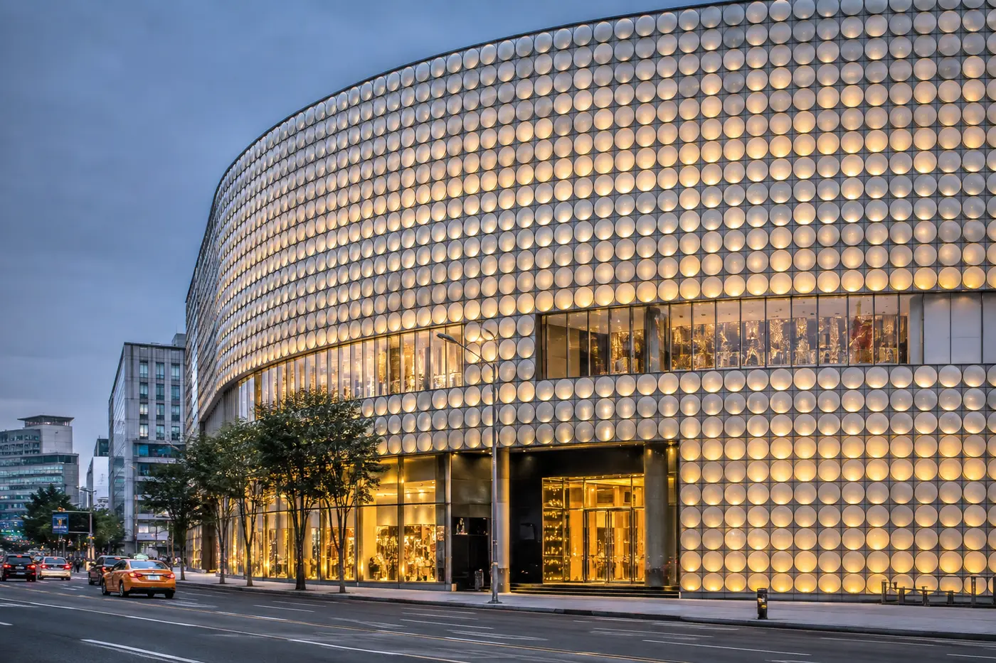 The glowing glass-disc facade of a luxury department store in Apgujeong