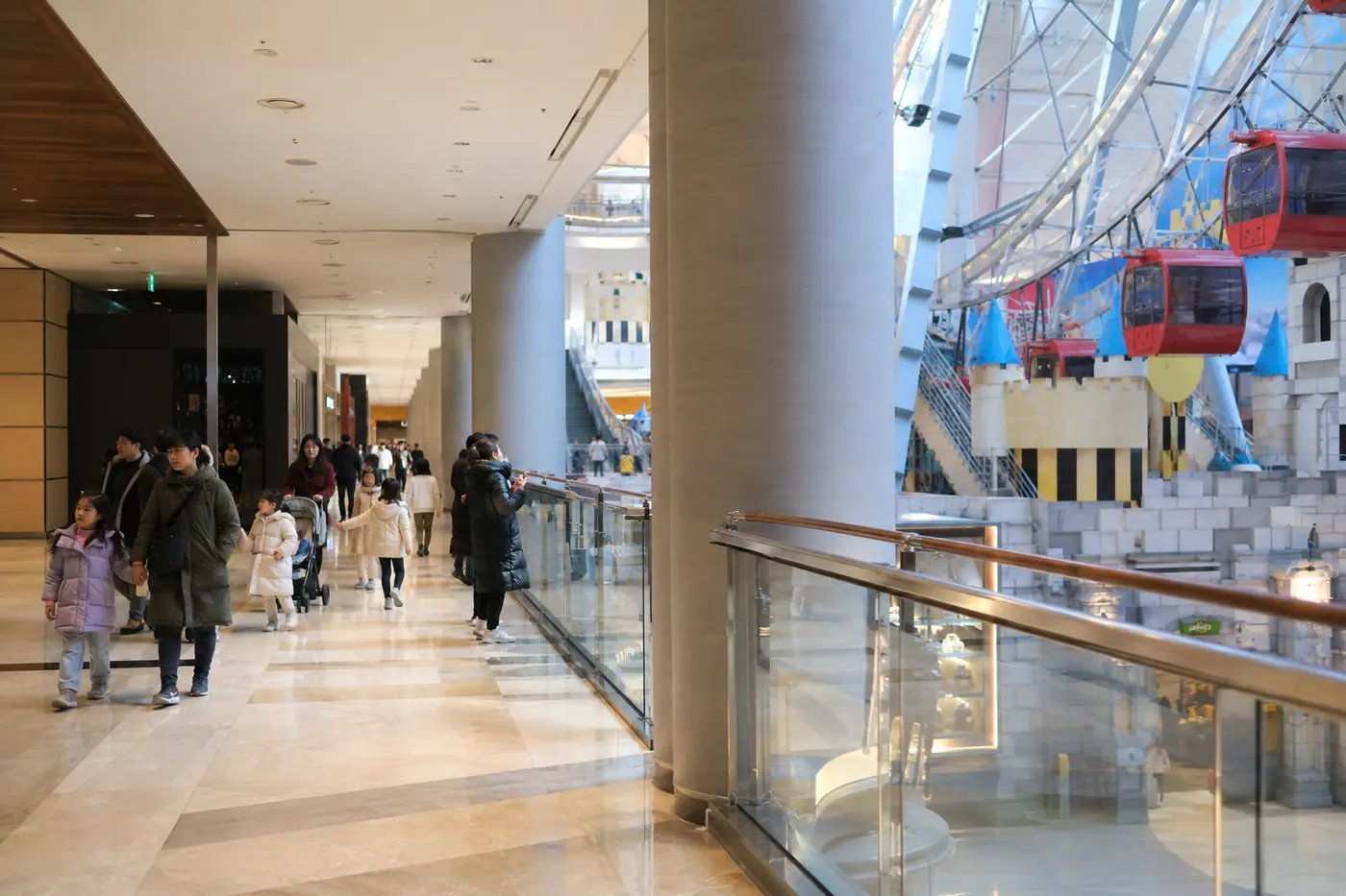 Families moving through COEX Mall near a large indoor attraction