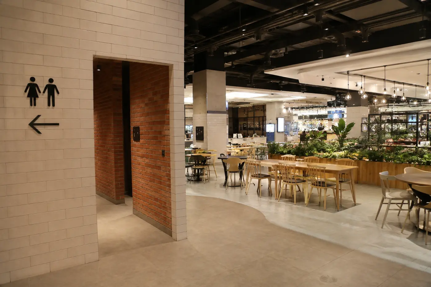 A family-friendly food hall seating area and clear restroom signage