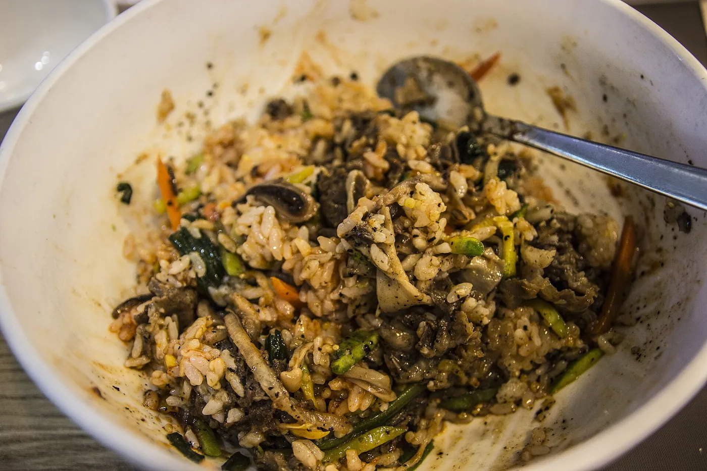 A bowl of bibimbap topped with vegetables, beef and egg