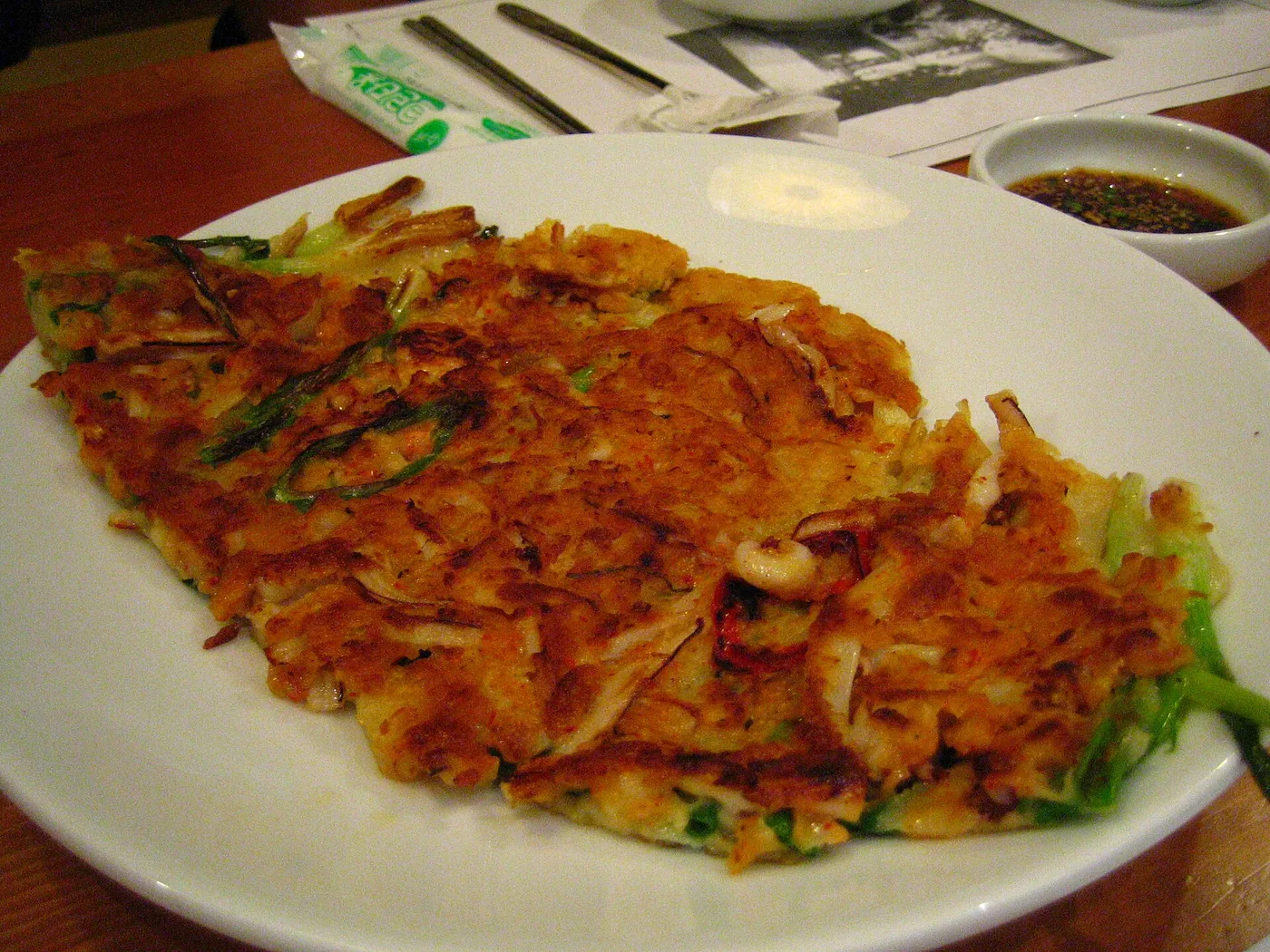 Golden bindaetteok mung-bean pancakes served with makgeolli